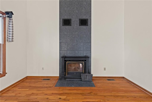 unfurnished living room with visible vents, baseboards, and wood finished floors