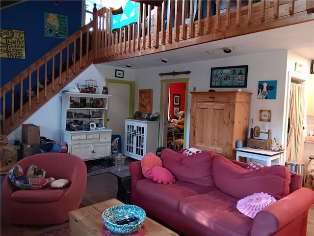 living room with stairway, a high ceiling, and wood finished floors