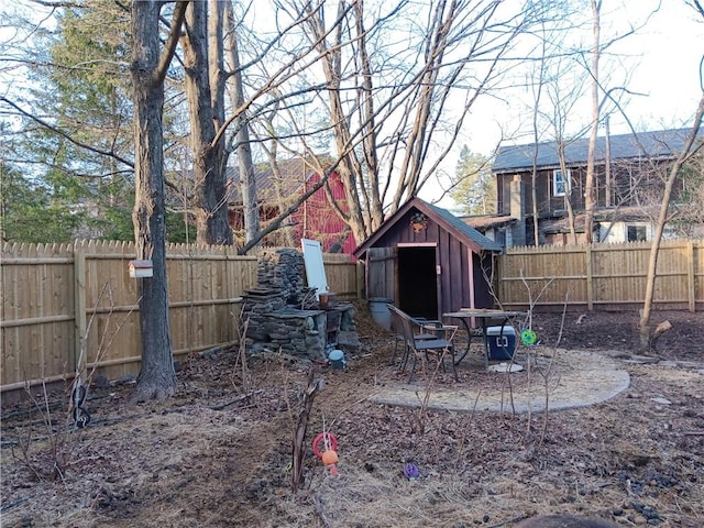 view of yard with a fenced backyard, a storage shed, and an outdoor structure