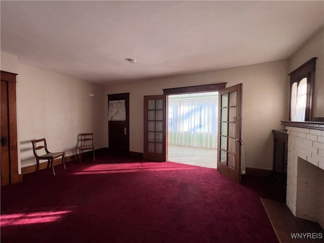 unfurnished room featuring a fireplace, baseboards, and carpet floors