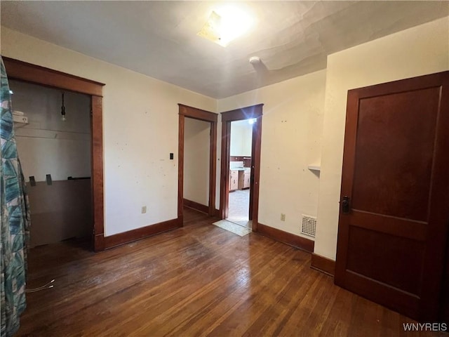 unfurnished bedroom featuring visible vents, baseboards, and wood-type flooring