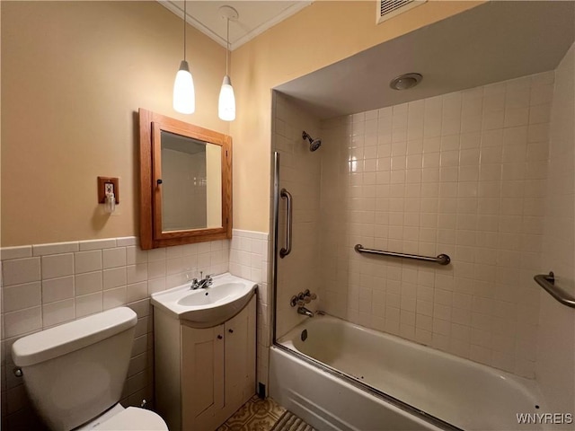 bathroom with visible vents, ornamental molding, tile walls, toilet, and shower / bathtub combination