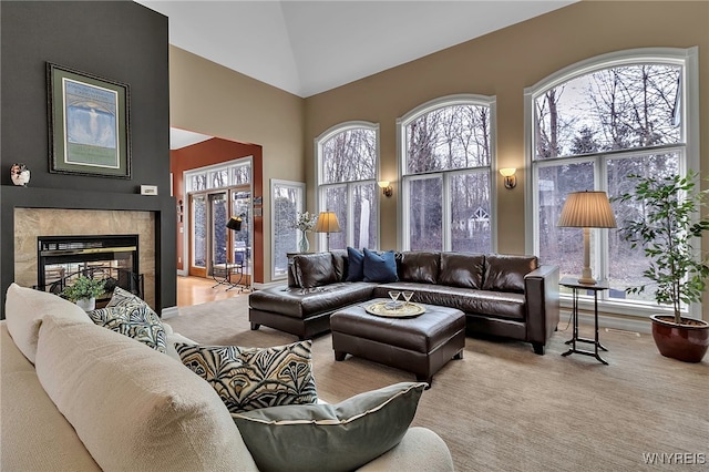 living area featuring carpet flooring, a fireplace, and high vaulted ceiling