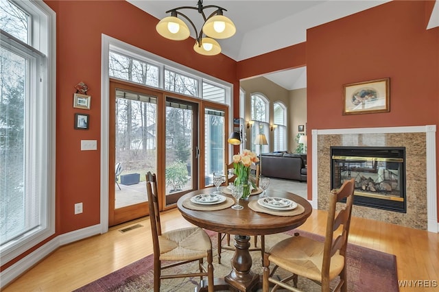 dining area featuring an inviting chandelier, light wood-style flooring, a healthy amount of sunlight, and visible vents