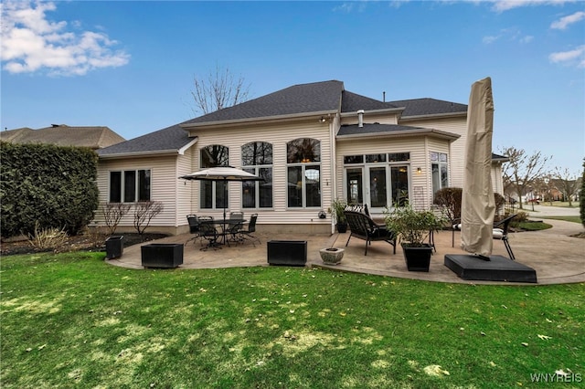 rear view of house with a patio area and a lawn