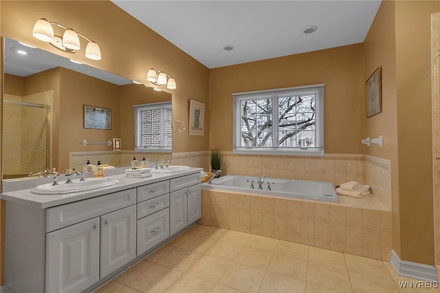 bathroom featuring tile patterned flooring, a shower stall, a bath, and a sink