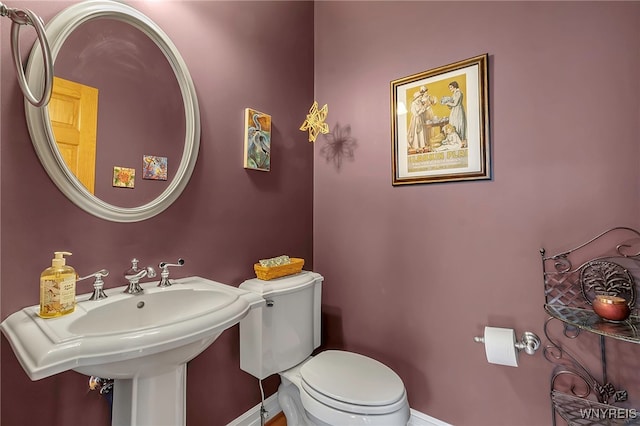 bathroom featuring a sink, baseboards, and toilet