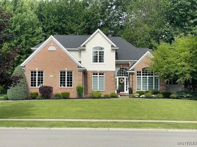 traditional-style house with brick siding and a front yard