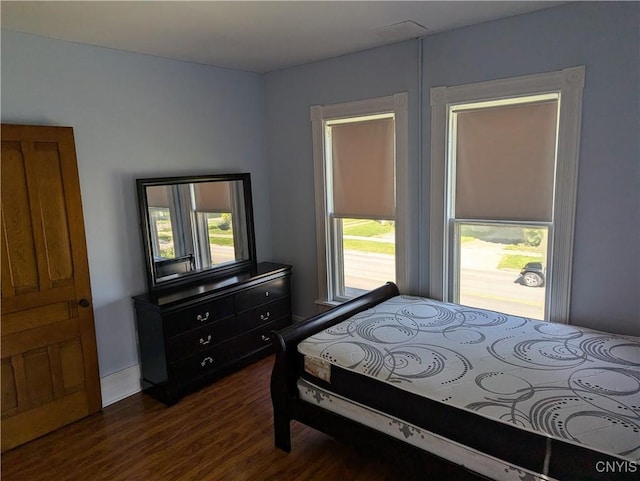 bedroom with dark wood-type flooring and multiple windows