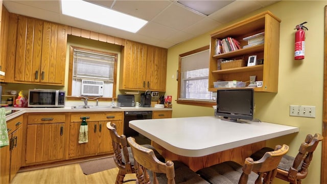 kitchen with stainless steel microwave, a peninsula, a breakfast bar area, and light countertops