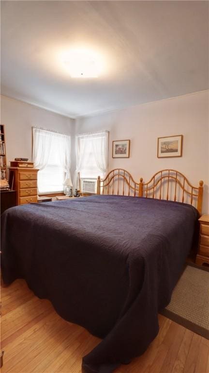 bedroom featuring light wood finished floors and cooling unit