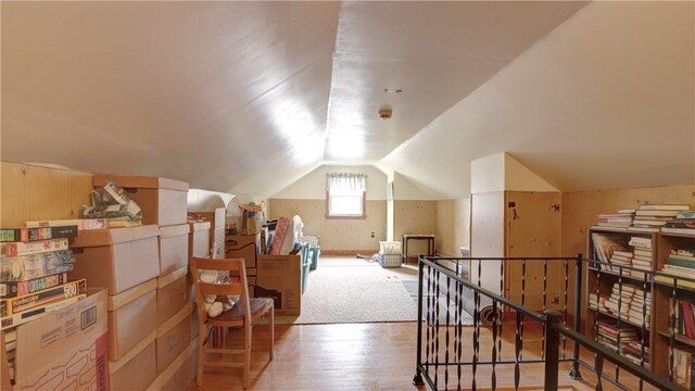 additional living space with wood finished floors and vaulted ceiling