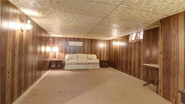 unfurnished room featuring carpet and wood walls