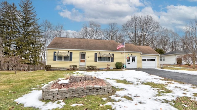 ranch-style home featuring an attached garage, driveway, and a front yard