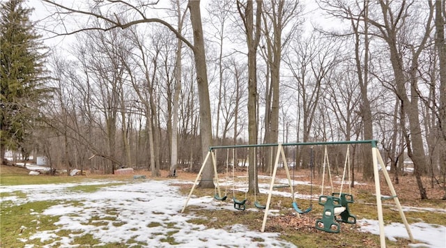 yard layered in snow featuring a carport and playground community