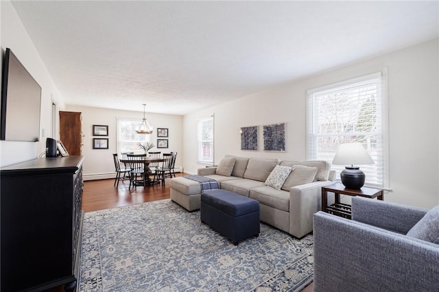 living area featuring a baseboard heating unit and dark wood-style flooring