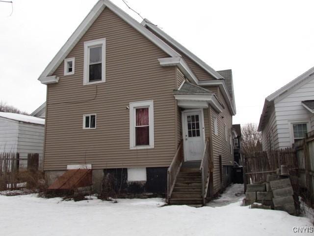 snow covered house featuring entry steps