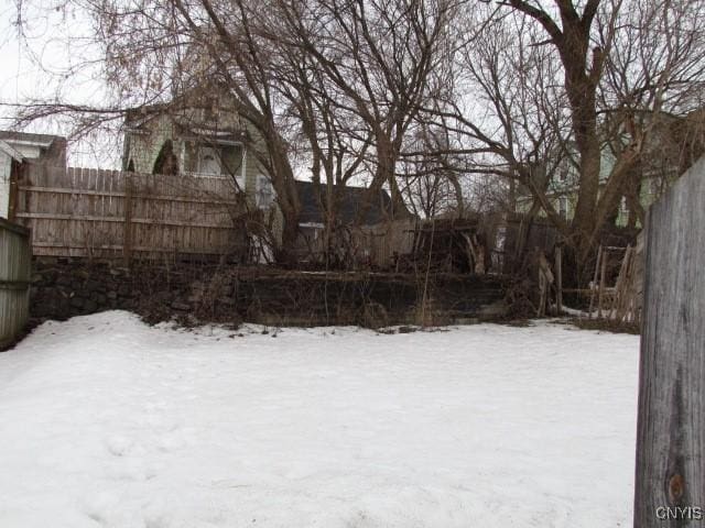 yard layered in snow featuring fence