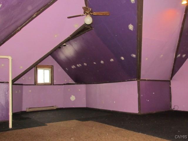 bonus room featuring vaulted ceiling and a baseboard radiator