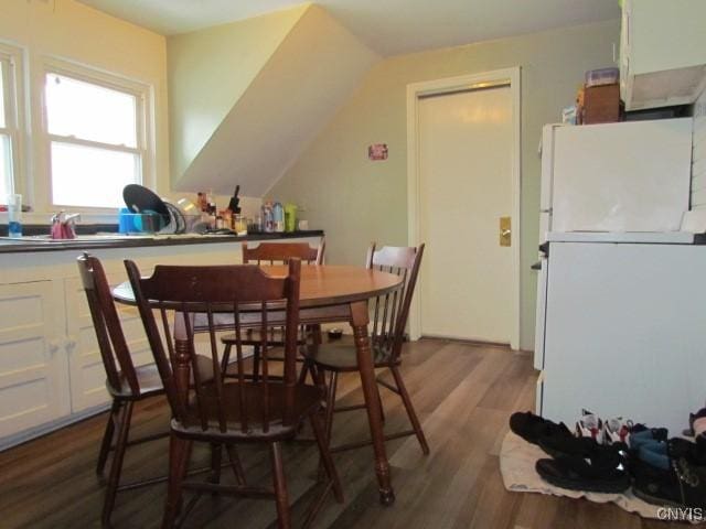 dining space with lofted ceiling and dark wood-style flooring