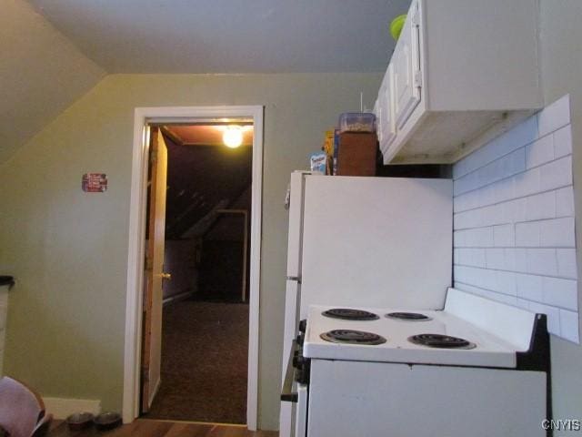 kitchen with lofted ceiling, white cabinets, and white range with electric cooktop