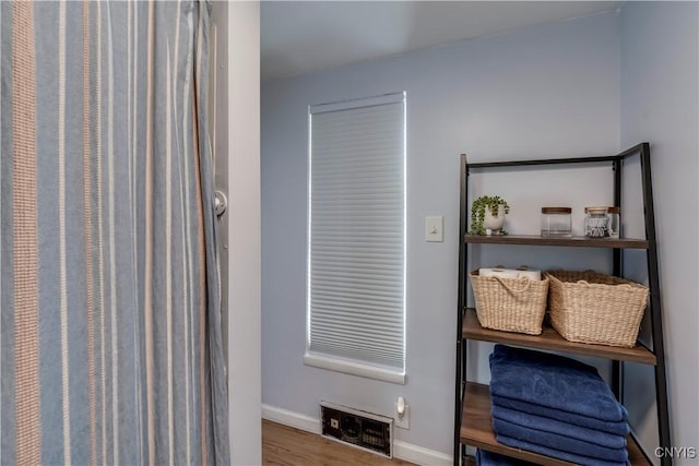 interior space featuring visible vents, baseboards, and wood finished floors