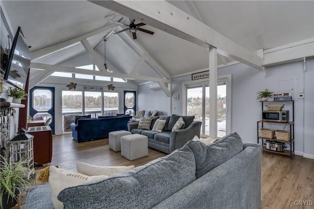 living area featuring beamed ceiling, high vaulted ceiling, a ceiling fan, wood finished floors, and baseboards