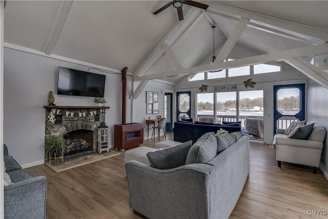 living room with beam ceiling, high vaulted ceiling, a ceiling fan, wood finished floors, and baseboards