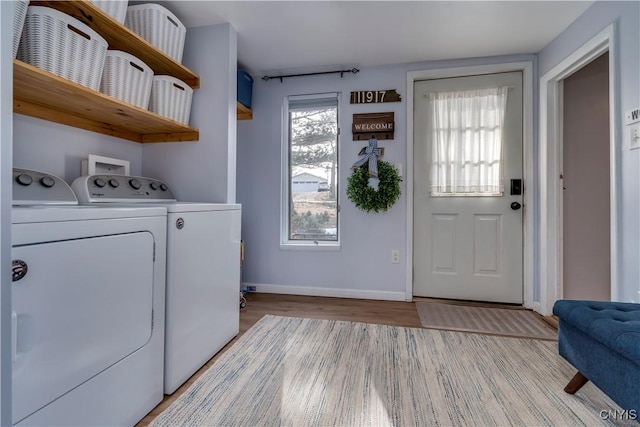 laundry room featuring laundry area, light wood-style flooring, baseboards, and washing machine and clothes dryer