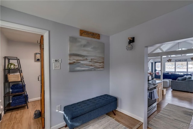 corridor featuring baseboards and wood finished floors