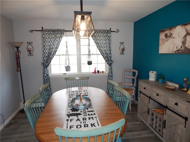 dining area featuring baseboards, an inviting chandelier, and wood finished floors