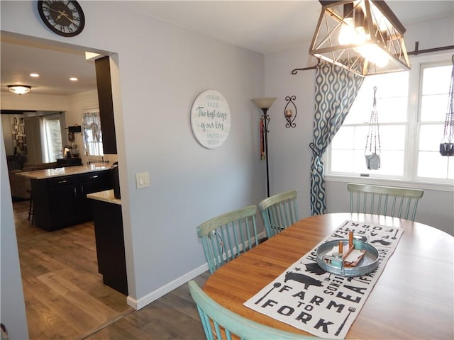 dining space with recessed lighting, a chandelier, baseboards, and wood finished floors