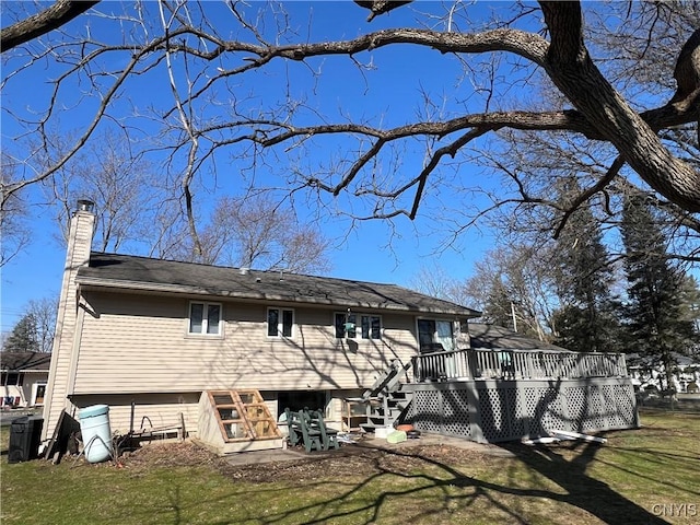 rear view of house featuring a lawn, a chimney, and a deck