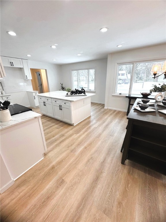 kitchen featuring recessed lighting, white cabinets, a center island, and light wood finished floors