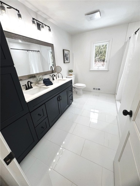 bathroom with tile patterned flooring, visible vents, toilet, double vanity, and a sink