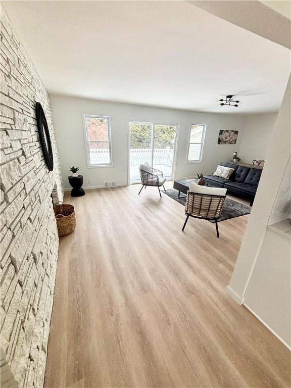 living room with visible vents, baseboards, and wood finished floors