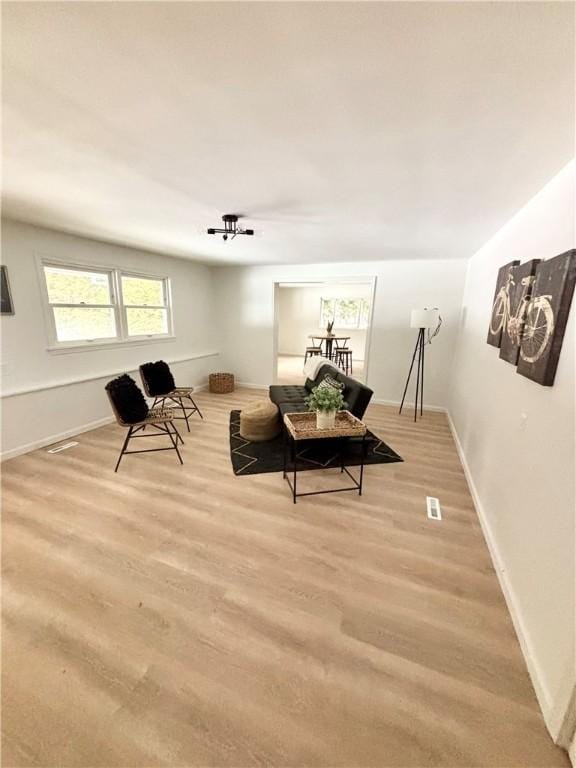 living area with light wood-style flooring and baseboards