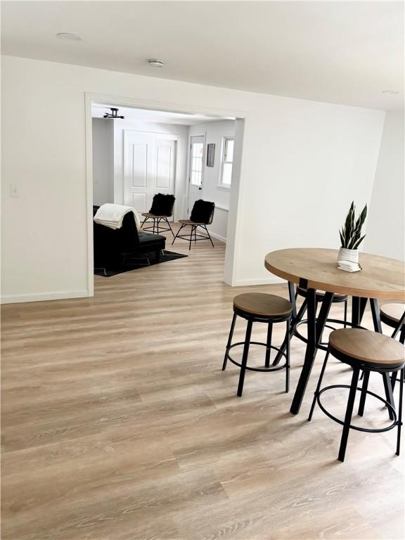 dining room with light wood-type flooring and baseboards