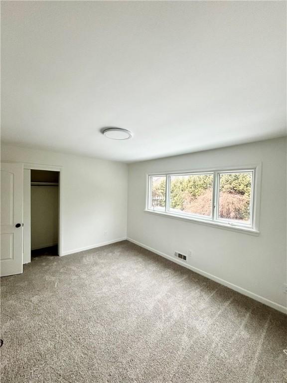 unfurnished bedroom with a closet, visible vents, baseboards, and carpet