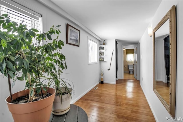 hallway with baseboards and light wood-style flooring