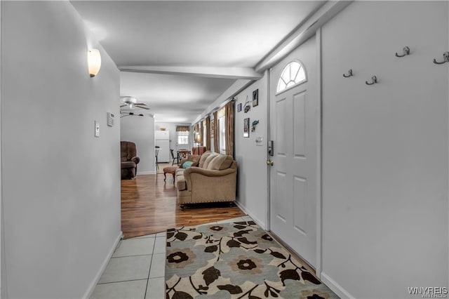 foyer with light tile patterned floors, plenty of natural light, baseboards, and a ceiling fan