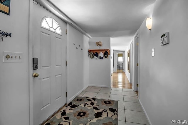 entryway with light tile patterned floors and baseboards