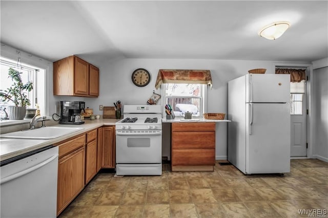 kitchen featuring plenty of natural light, white appliances, light countertops, and a sink