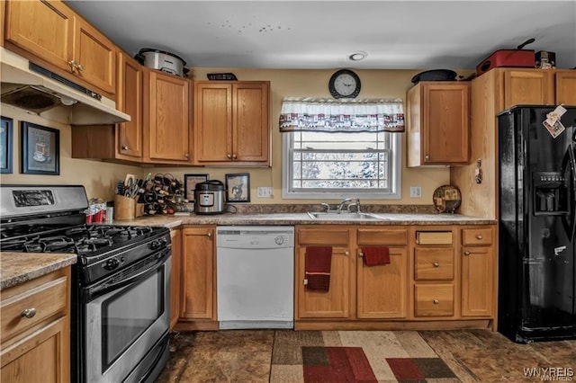 kitchen featuring black fridge, under cabinet range hood, a sink, white dishwasher, and stainless steel range with gas stovetop