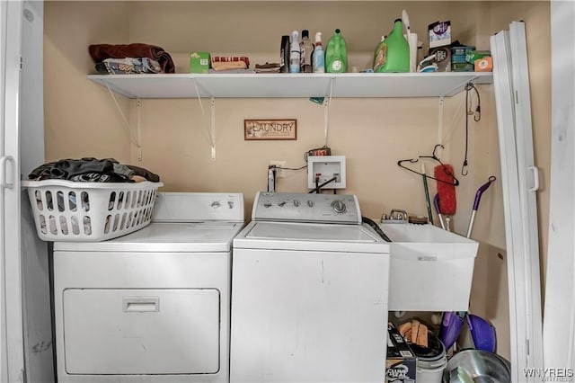 laundry area with laundry area, washing machine and dryer, and a sink