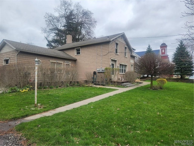 rear view of house featuring a yard and a chimney