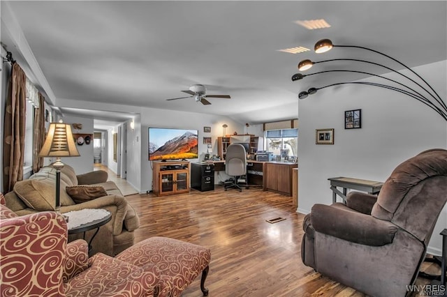 living room featuring baseboards, ceiling fan, and wood finished floors