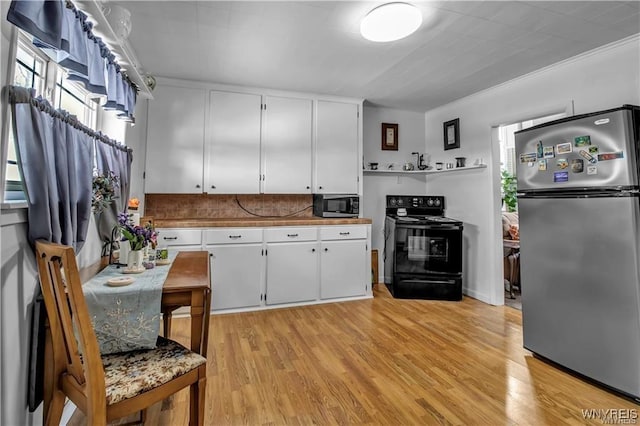 kitchen featuring light wood-type flooring, backsplash, appliances with stainless steel finishes, and white cabinets