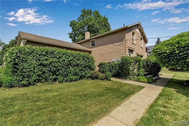 view of property exterior featuring a chimney and a yard