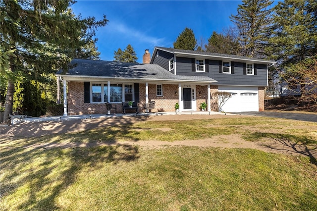 traditional home with aphalt driveway, an attached garage, brick siding, and a front lawn